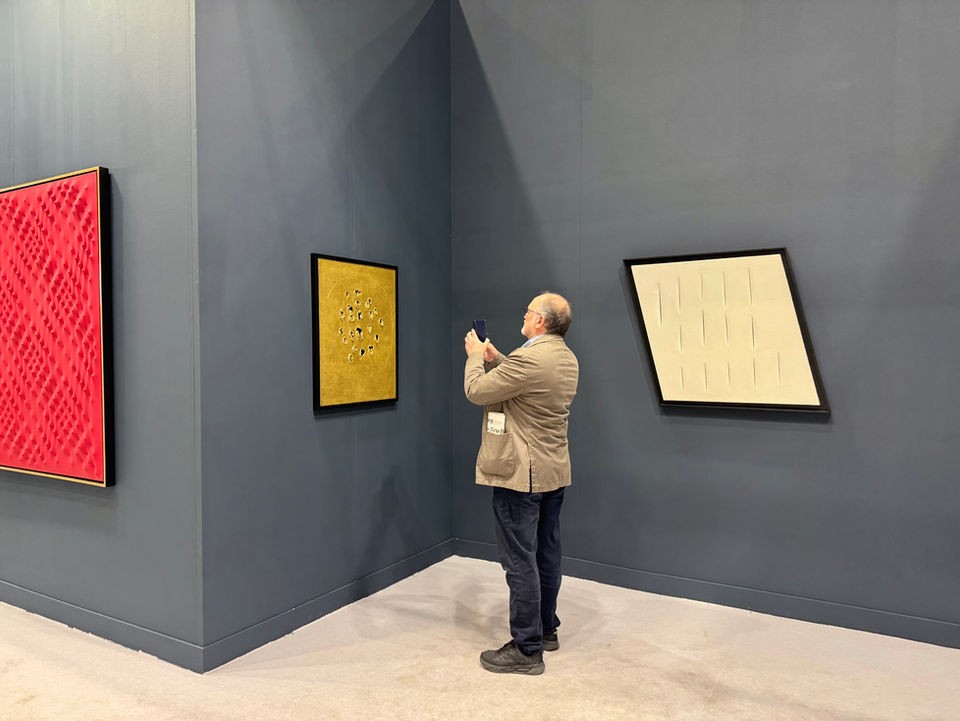 收藏家在展览中观察当代艺术作品